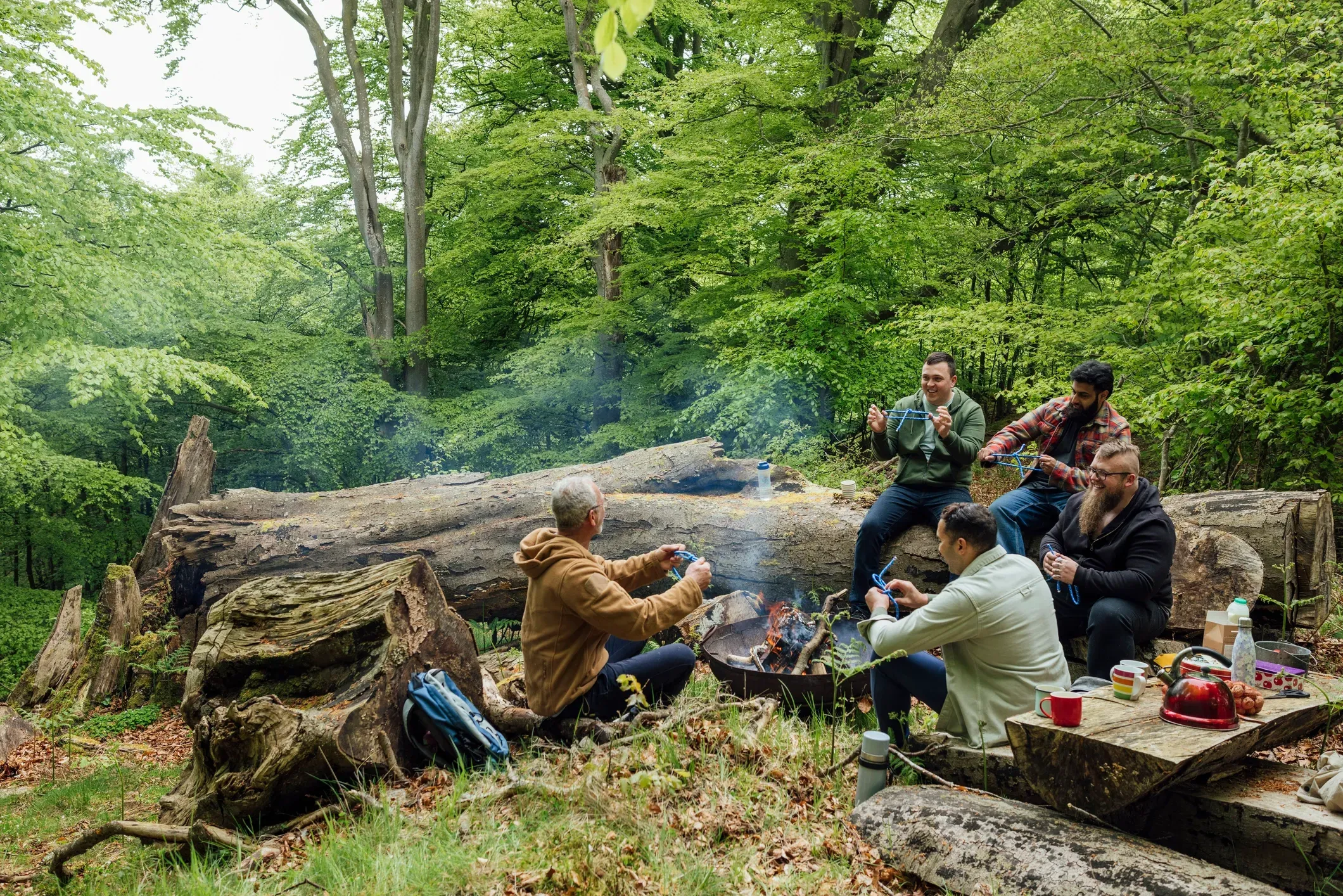 Group enjoying campfire in lush forest